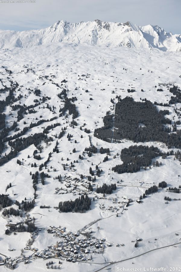 Dorf links unten: Sarn, Blick westtwärts zur Alp da Sarn. (Position 2'750'687.29, 1'176'162.79). In der Mitte: Sarn-Lescha mit Skianlagen nach Dultschegnas und hinauf zur Sarner-Alp auf 2080 m.ü.M.